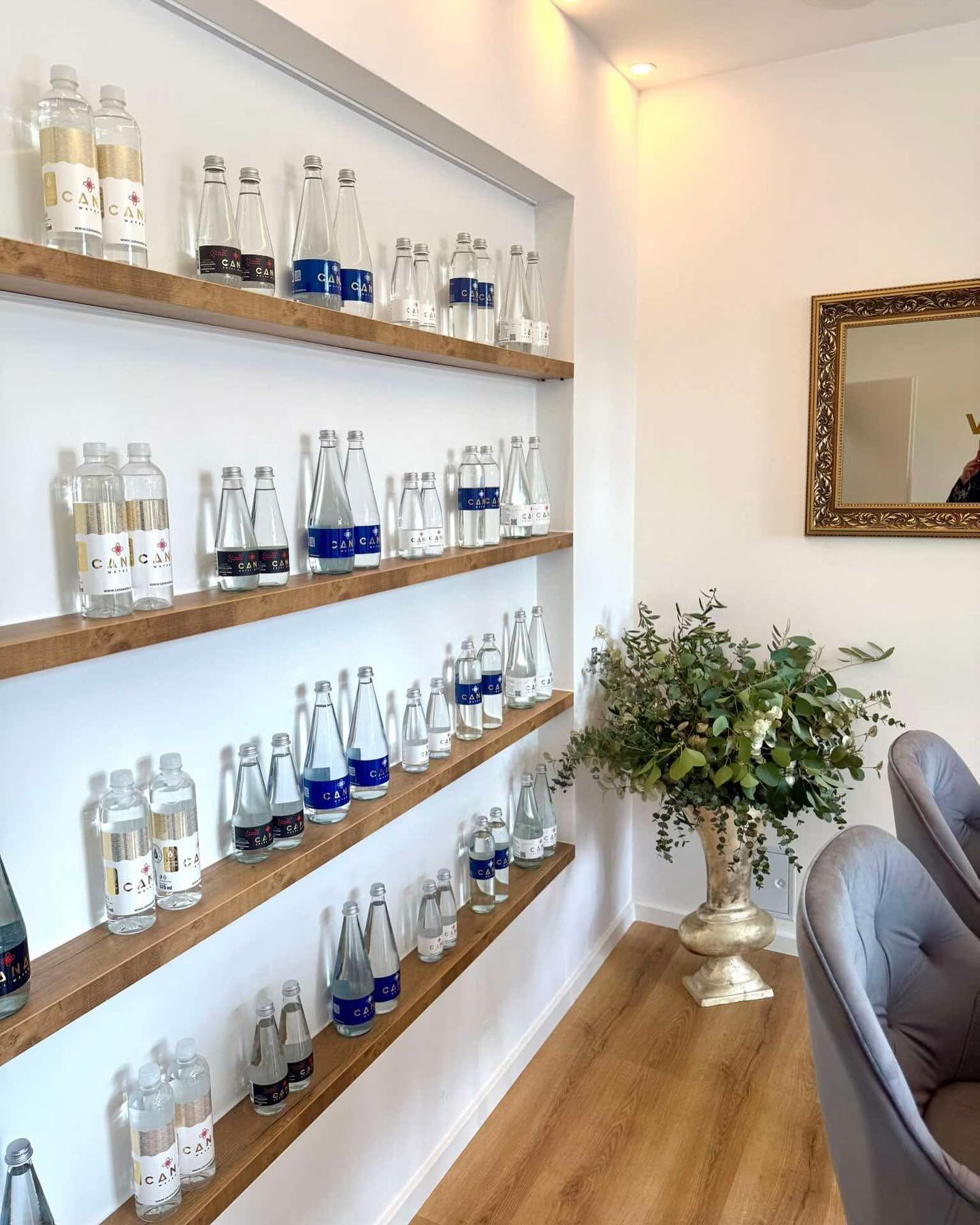 Cana Royal Water showroom - private-label bottle lineup on oak shelves
